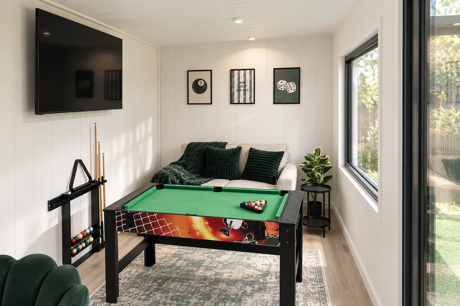 Games room display with a pool table and wall-mounted television in the Noah showroom