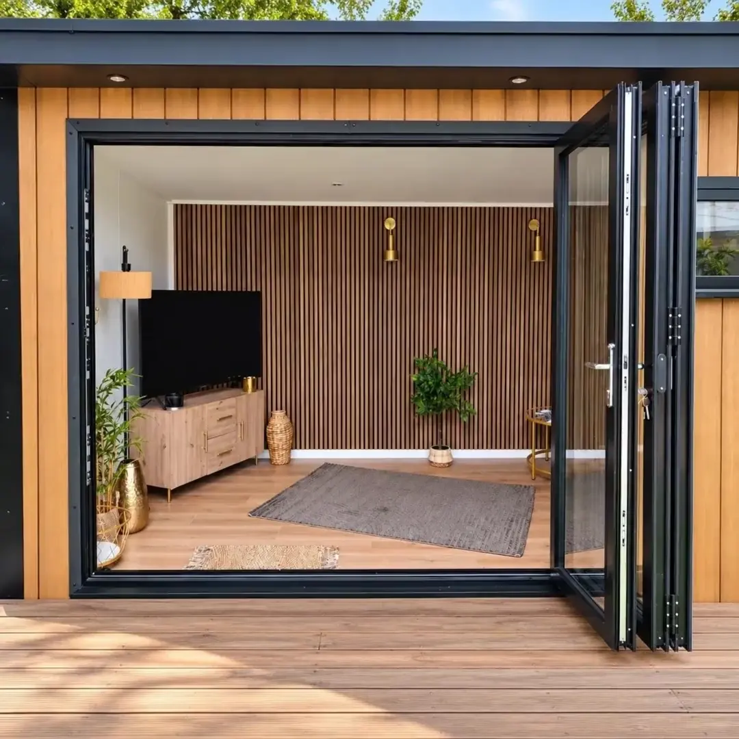 Showroom display room with bi-fold doors open onto a television and slatted timber wall